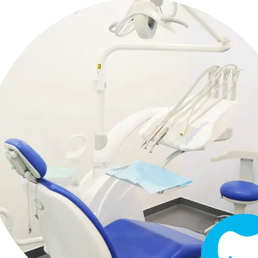 Consultório da clínica: cadeira azul e unidade branca.
